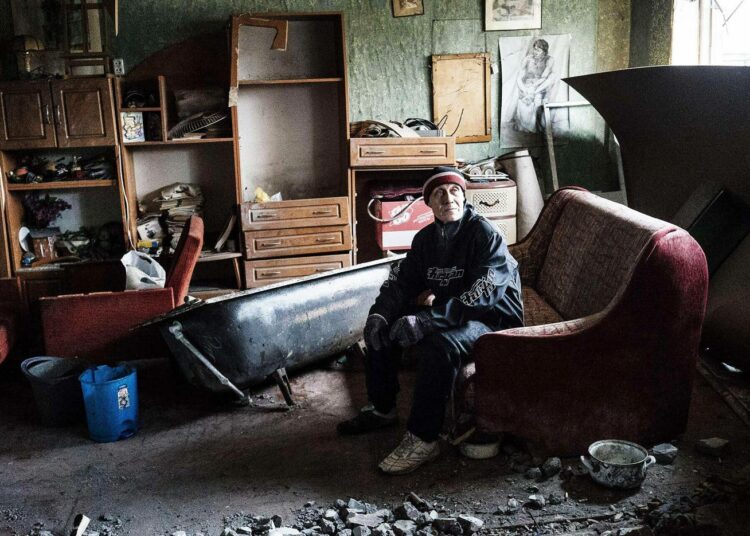 Mies taistelujen tuhoamassa asunnossaan Donetskissa.