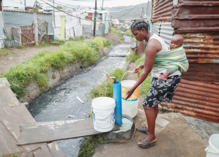 Kapkaupungin Masiphumelelen kaupunginosan asukas otti vettä kunnallisesta vesijohdosta kriisikeväänä 2018.