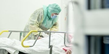 Suojavarusteisiin pukeutunut hoitaja otti näytettä koronaepäillyltä potilaalta Turun yliopistollisessa keskussairaalassa 3. huhtikuuta.