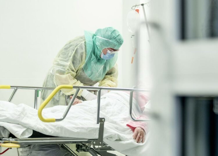 Suojavarusteisiin pukeutunut hoitaja otti näytettä koronaepäillyltä potilaalta Turun yliopistollisessa keskussairaalassa 3. huhtikuuta.