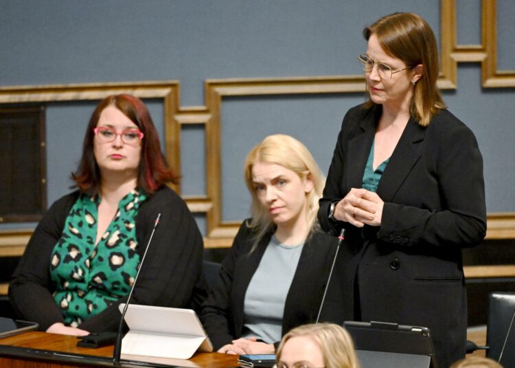 Veronika Honkasalo puhuu eduskunnan täysitunnossa. Vieressä seuraavat vasemmistoliiton kansanedustajat Pia Lohikoski ja Mai Kivelä.