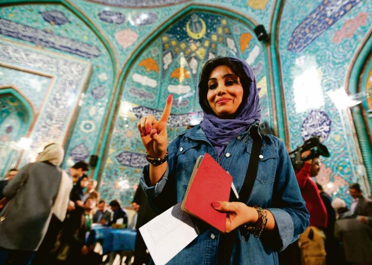 Iranilaisnainen näytti musteeseen kastettua sormeaan äänestyspaikalla Teheranissa. Parlamenttiin valittiin aiempaa enemmän naisia.