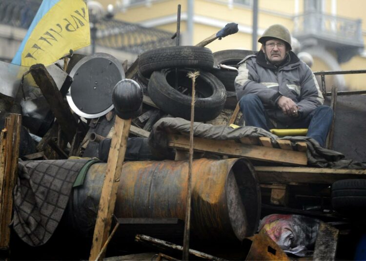 Mies barrikadeilla Kiovan Maidanin aukiolla helmikuussa 2014.