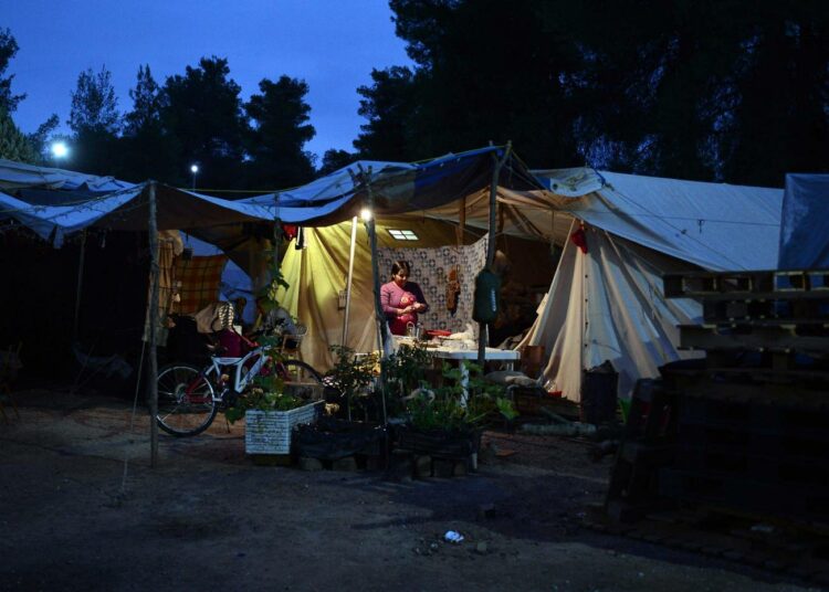 Kurdiperhe valmistautuu illalliselle Kreikassa Ateenan pohjoispuolella olevalla pakolaisleirillä.