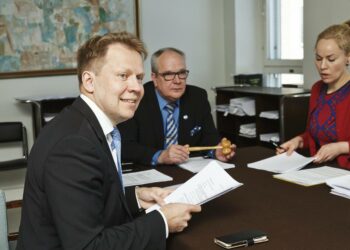 Talousvaliokunta hyväksyi hallintarekisterilain vapun alla. Kuvassa vasemmalta valiokunnan varapuheenjohtaja Harri Jaskari, puheenjohtaja Kaj Turunen ja jäsen Hanna Sarkkinen.