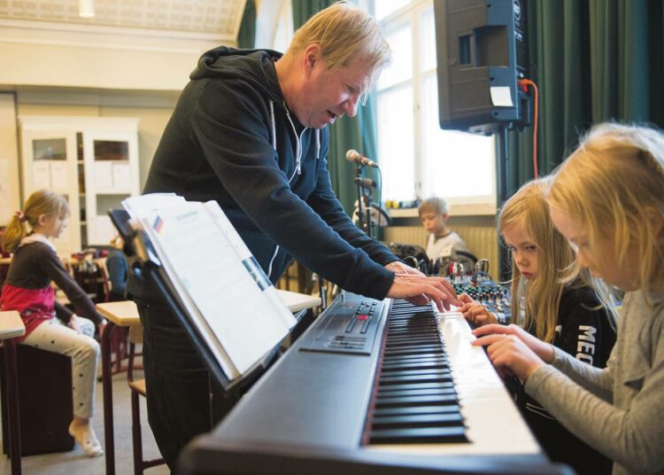 Jussi Liski opettaa erilaisten soitinten hallintaa. Klaara ja Ulla opettelevat soittamaan kosketinsoittimilla.