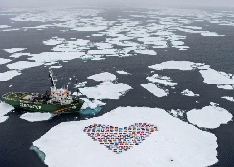 Greenpeacen My Arctic Sunrise-aluksen miehistö muodosti sydämen muotoisen kuvion 193 YK:n jäsenmaan lipuista jäälautalle 14. syyskuuta kutsuna Arktiksen suojelemiseksi.