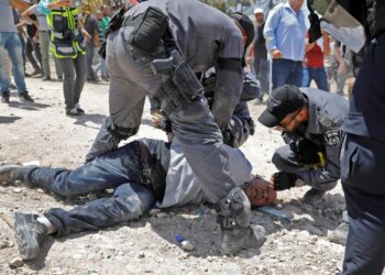 Yhdysvallat perusteli eroaan ihmisoikeusneuvoston suhtautumisella Israeliin. Kuvassa Israelin turvallisuusjoukot pidättävät keskiviikkona mielenosoittajan Khan al-Ahmarin beduiinikylässä Jerusalemin itäpuolella.