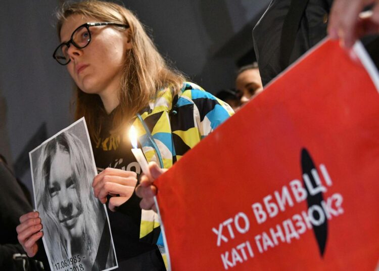 Mielenosoittaja Ukrainan sisäministeriön edessä sunnuntaina, kyltissä lukee: ”Kuka tappoi Kati Gandzjukin?”