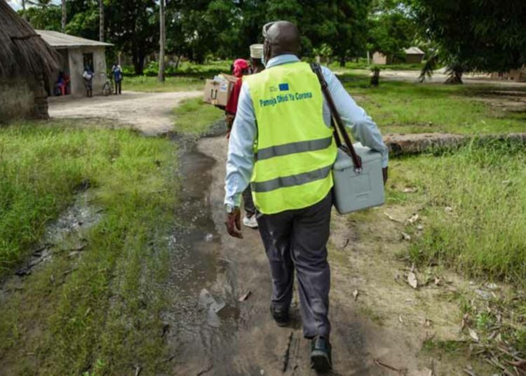 Terveydenhuollon yhteisötyöntekijä kulkee ovelta ovelle rokottamassa ihmisiä Nanyamban kylässä Mtwaran alueella Kaakkois-Tansaniassa.