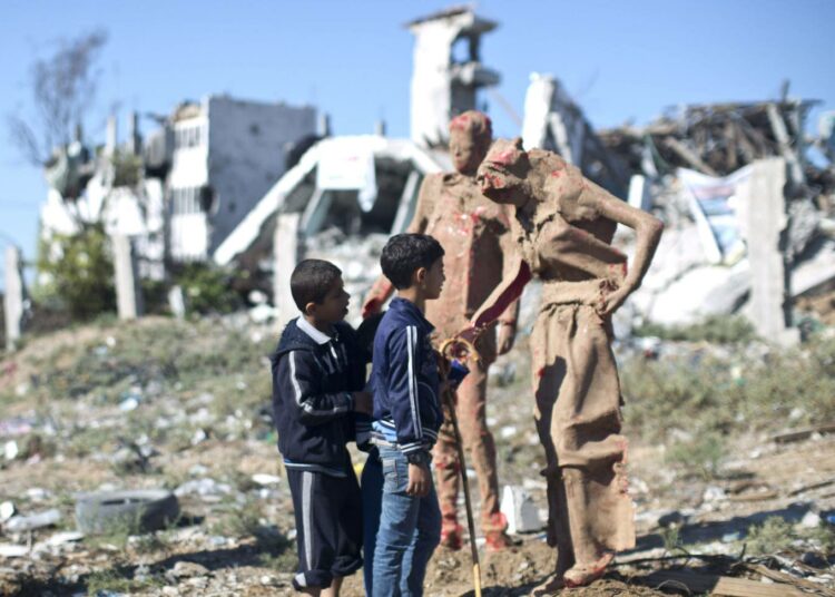 Palestiinalaislapsia tutkimassa taiteilija Eyad Sabbahin tekemää patsasta Gaza Cityn lähiössä. Sabbah on tehnyt patsaita Israelin viime kesän konfliktissa tuhoamien talojen jäännöksistä.