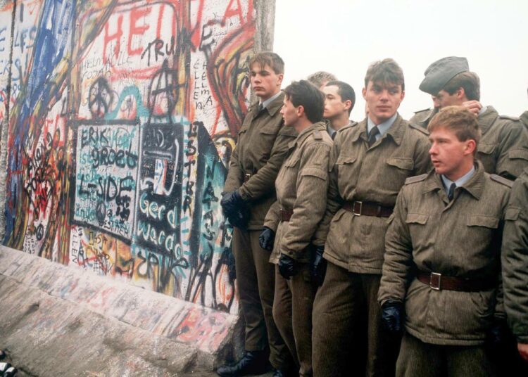 Berliinin murtumisesta tuli tänä syksynä kuluneeksi 30 vuotta. Kuvassa itäsaksalaisia rajavartijoita muurin aukossa 11. marraskuuta 1989.