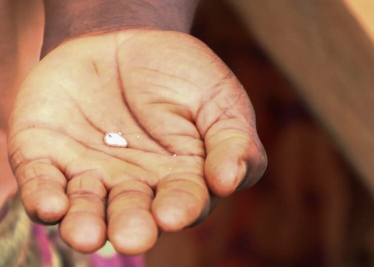 Pienimuotoinen kullankaivaja Sharon Ambale pitää kädessään kullan ja elohopean amalgamiseosta.