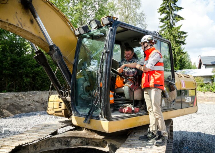 Paalutuskoneen kuljettaja Markku Ilkola ja projektista vastaava Pekka Pihlajamäki tarkistavat työmaan paalukartat.