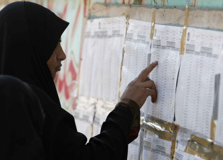 Nainen tutkimassa ehdokaslistoja maaliskuun alun parlamenttivaaleissa Basrassa Etelä-Irakissa.