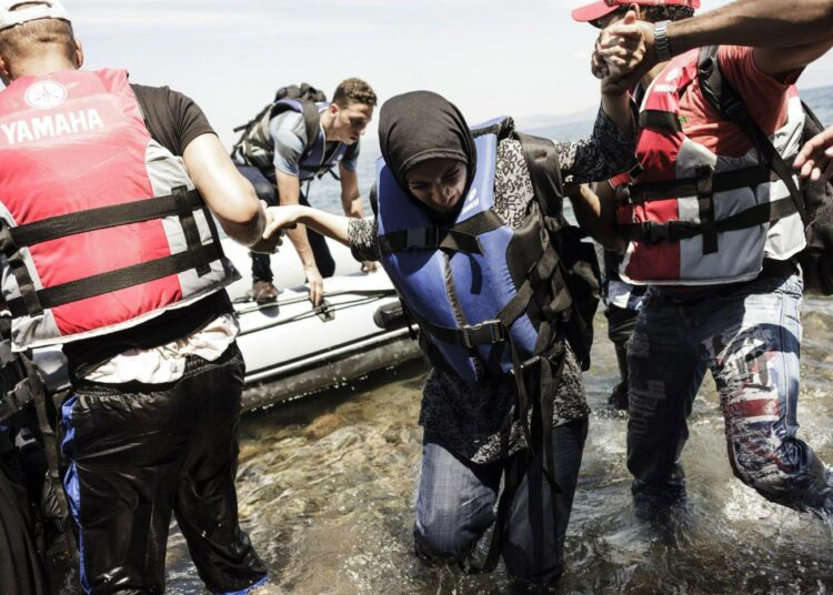 Kumiveneessä saapunutta naista autettiin maihin Kreikan Lesvoksen saarella elokuun puolivälissä.