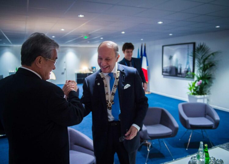 Ranskan ulkoministeri Laurent Fabius (oik.) on luvannut antaa lopullisen sopimusluonnoksen varhain lauantaiaamuna, jotta se voitaisiin allekirjoittaa puolen päivän aikoihin lauantaina. Fabius tervehti Marshallinsaarten ulkoministeri Tony de Brumia torstaina.
