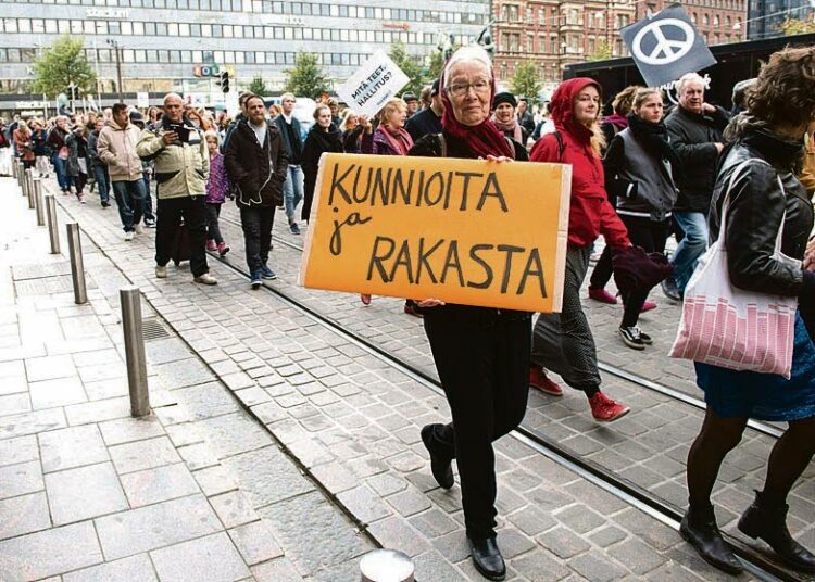 Suuri joukko ihmisiä osallistui rasismia ja fasismia vastustaneeseen Peli poikki -mielenosoitukseen Helsingissä 24. syyskuuta. Kati Peltola kantoi Kunnioita ja rakasta -kylttiä kulkueessa.