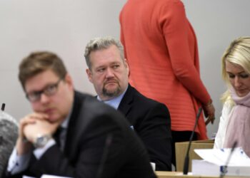 Kansanedustaja Jari Myllykoski (keskellä) eduskunnan istunnossa marraskuun alussa.