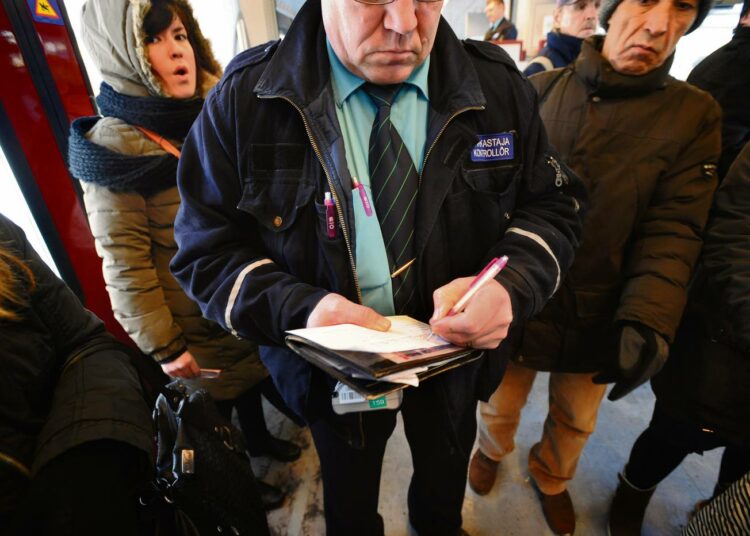 Matti Liimatainen kirjoittaa tarkastusmaksulappua liputta matkustaneelle asiakkaalle.