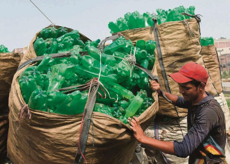 Tyhjiä muovipulloja puretaan keräyslastista Pakistanin Lahoressa. Tänä päivänä yhä suurempi osa yhdyskuntajätteestä poltetaan kaatopaikoille hautaamisen sijaan.