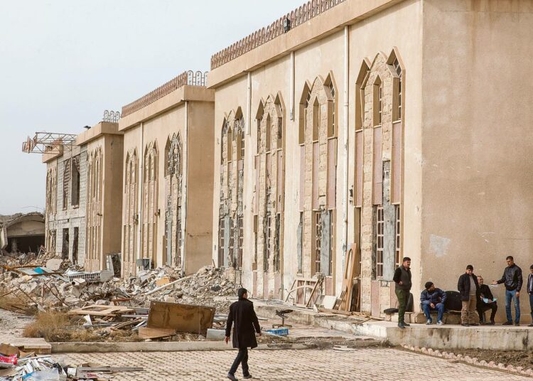 Mies kulki pahoin vaurioituneen Mosulin yliopiston rakennuksen ohitse. Isisin rakennuksille aiheuttamien tuhojen arvoksi on arvioitu 46 miljardia dollaria.