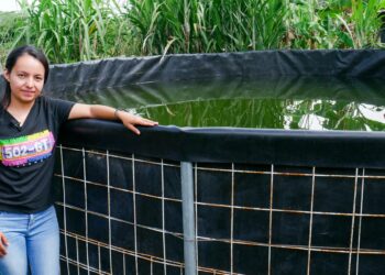 Merlyn Sandoval seisoo sadeveden keräilytankin vieressä pienellä tontillaan San Jose Las Pilasin kylässä Itä-Guatemalassa. Sandovalin perhe on mukana hankkeessa, jolla pyritään lievittämään kuivuuden vaikutuksia Keski-Amerikan kuivassa käytävässä.