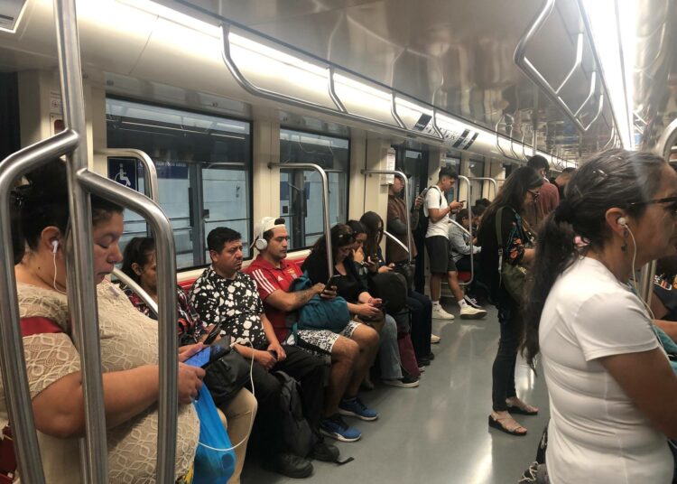 Santiagon metron matkustajat uppoutuneina kännyköihinsä, joka on nykyään yleisin tapa seurata uutisia.