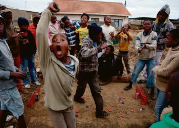 Lapset leikkivät pullonkorkeilla jalkapallon MM-kisoja Sowetossa Johannesburgin laitamilla. Keskiluokkaistunut Soweto on toistaiseksi säästynyt muukalaisvastaiselta väkivallalta.