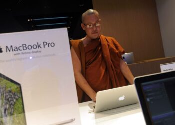 Buddhalaismunkki kokeilemassa Applen uutta tietokonetta yangoonilaisessa myymälässä.