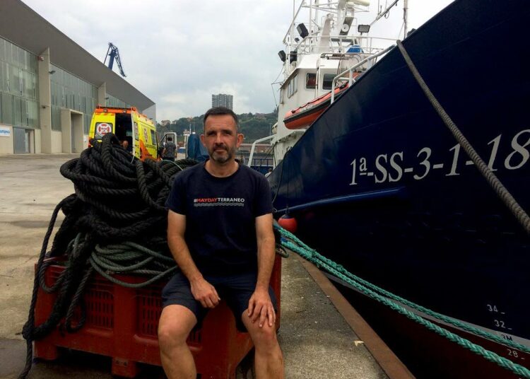 Iñigo Mijangos istuskelee pelastusalukseksi muutetun vanhan baskien kalastuslaivan Aita Marin vierellä.