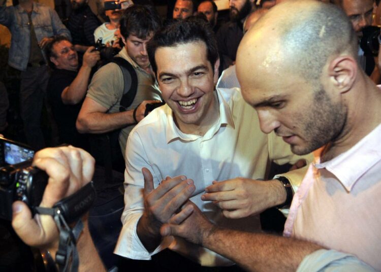 Syriza/Synaspismosin johtaja Aleksis Tsipras (kesk.) kannattajiensa juhlittavana.