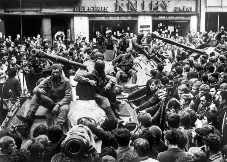 Väkijoukkojen ympäröimiä miehittäjiä Prahassa elokuussa 1968.