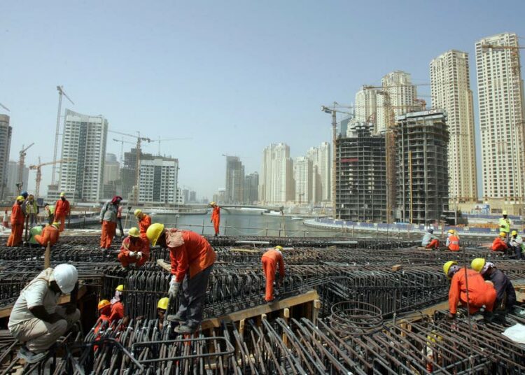 Pakistanilaiset siirtotyöläiset rakentavat pilvenpiirtäjää Dubaissa.