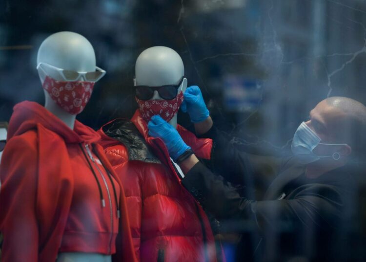 Somistaja asettaa mallinukeille maskeja moskovalaisessa myymälässä.