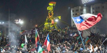 Ihmiset juhlivat Chilen pääkaupungin Santiagon Plaza Italia -aukiolla sunnuntai-iltana, kun diktatuurin aikaisen perustuslain hylkääminen tuli selväksi.