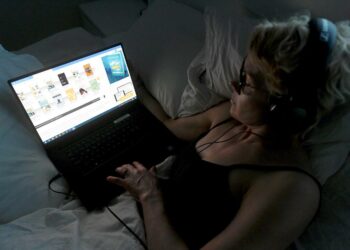 ”Suhtaudun penseästi puheenvuoroihin, joiden mukaan äänikirjan kuuntelemisella ei ole lukemisen kanssa mitään tekemistä”, kirjoittaa Veikka Lahtinen esseessään. Kuvassa nainen kuuntelee äänikirjaa internetistä.