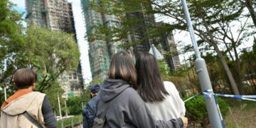 Hongkongilaiset nuoret katselivat tulipalossa mustuneita tornitaloja Tai Pon lähiössä joulukuun alussa.