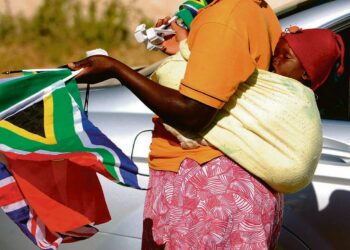 Pienen lapsen äiti kauppasi jalkapallon MM-kisoihin osallistuvien maiden lippuja Johannesburgin liikenteen keskellä viime viikolla. Paikallisilla katukauppiailla ei ole pääsyä kisapaikkojen läheisyyteen.
