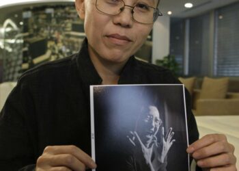 Perjantaina myönnetyn Nobelin rauhanpalkinnon saaneen Liu Xiaobon puoliso Liu Xia näyttää kuvaa miehestään.