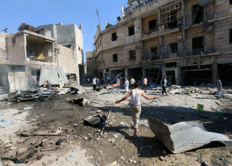 Syyrialaisia kerääntyi hallituksen joukkojen tynnyripommi-iskun räjähdyspaikalle Aleppossa 13. elokuuta.