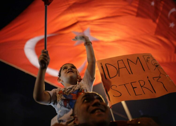 Turkin presidentin Recep Tayyip Erdoganin hallinto kukisti vallankaappausyrityksen viikonloppuna. Erdoganin hallinnon kannattajat osoittivat tukeaan Taksimin aukiolla sunnuntaina. Kyltin mukaan kannattaja haluaisi teloittaa vallankaappausta yrittäneitä.