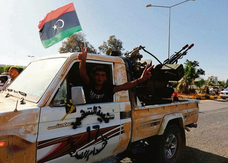 Libyan aamunkoitto -liittoumaan kuuluva taistelija näytti voitonmerkkiä viime sunnuntaina kapinallisten vallattua Libyan pääkaupungin Tripolin lentokentän kuukauden kestäneen taistelun jälkeen.