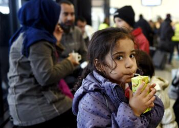 Irakilaisia turvapaikanhakijoita Torniossa syyskuussa. Kuvan kolmilapsinen perhe matkasi yli kuukauden ajan Irakin Bagdadista läpi Euroopan Suomeen. Perheen tytär Wed juo pillimehua äiti Luman ja isä Thaeerin keskustellessa taustalla.